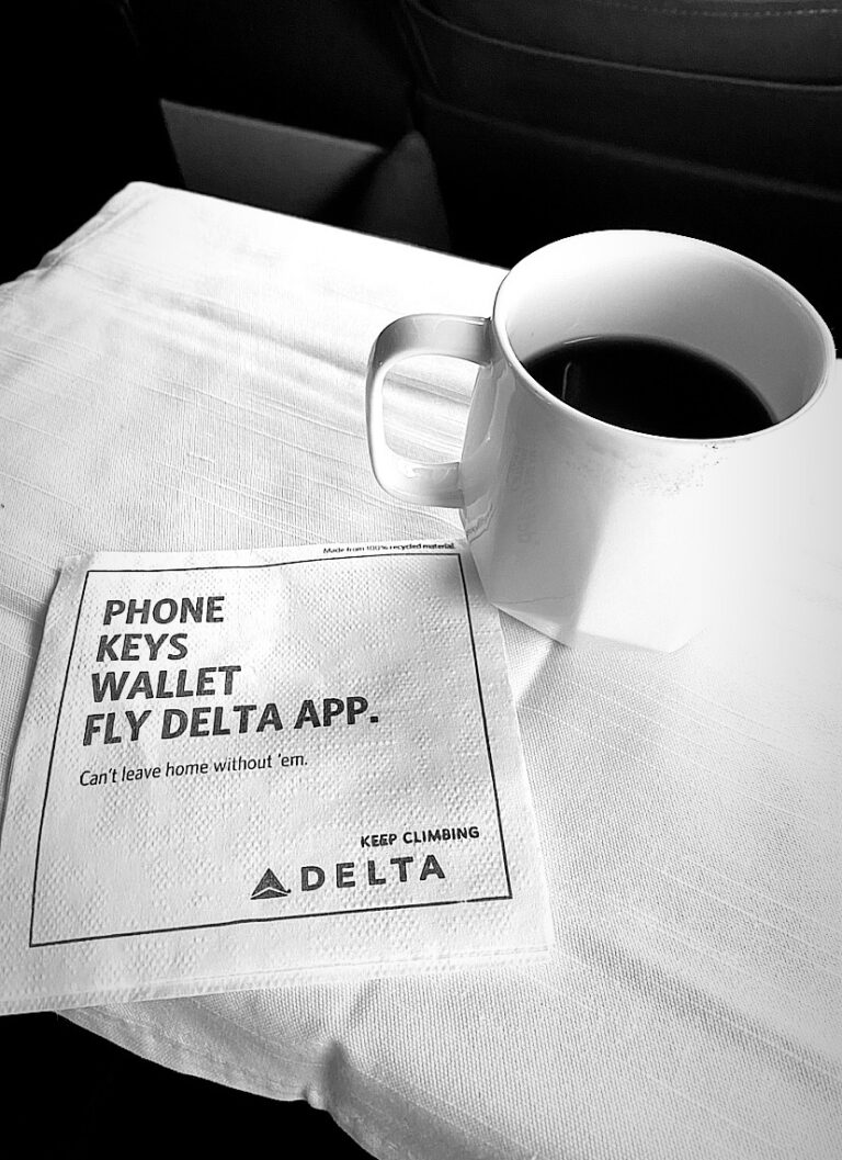 Cup of coffee and a napkin in a DELTA flight